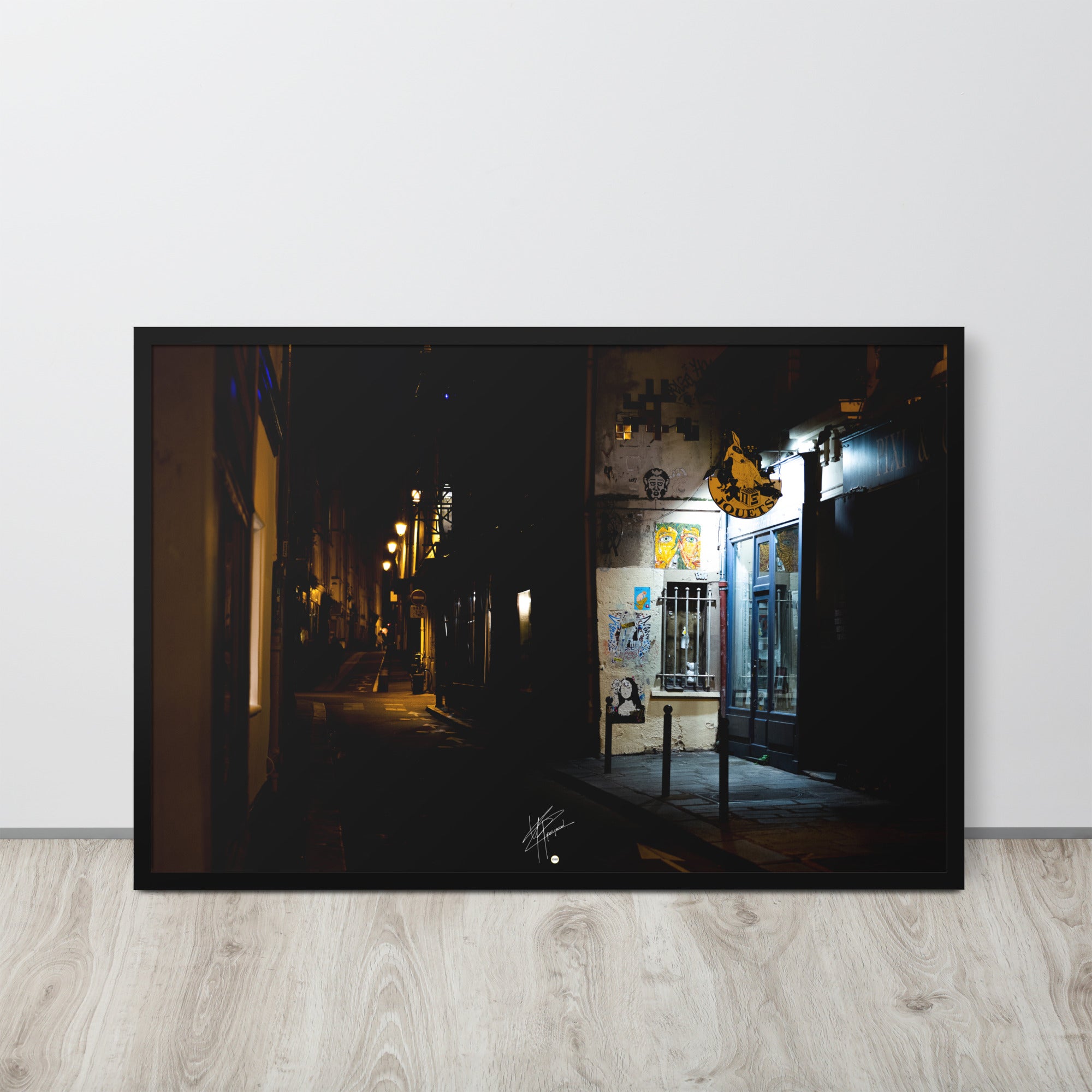 Photographie nocturne d'une rue parisienne, combinant éclats d'art urbain et lumière douce d'un magasin de jouets, évoquant la diversité et le charme artistique de la capitale.