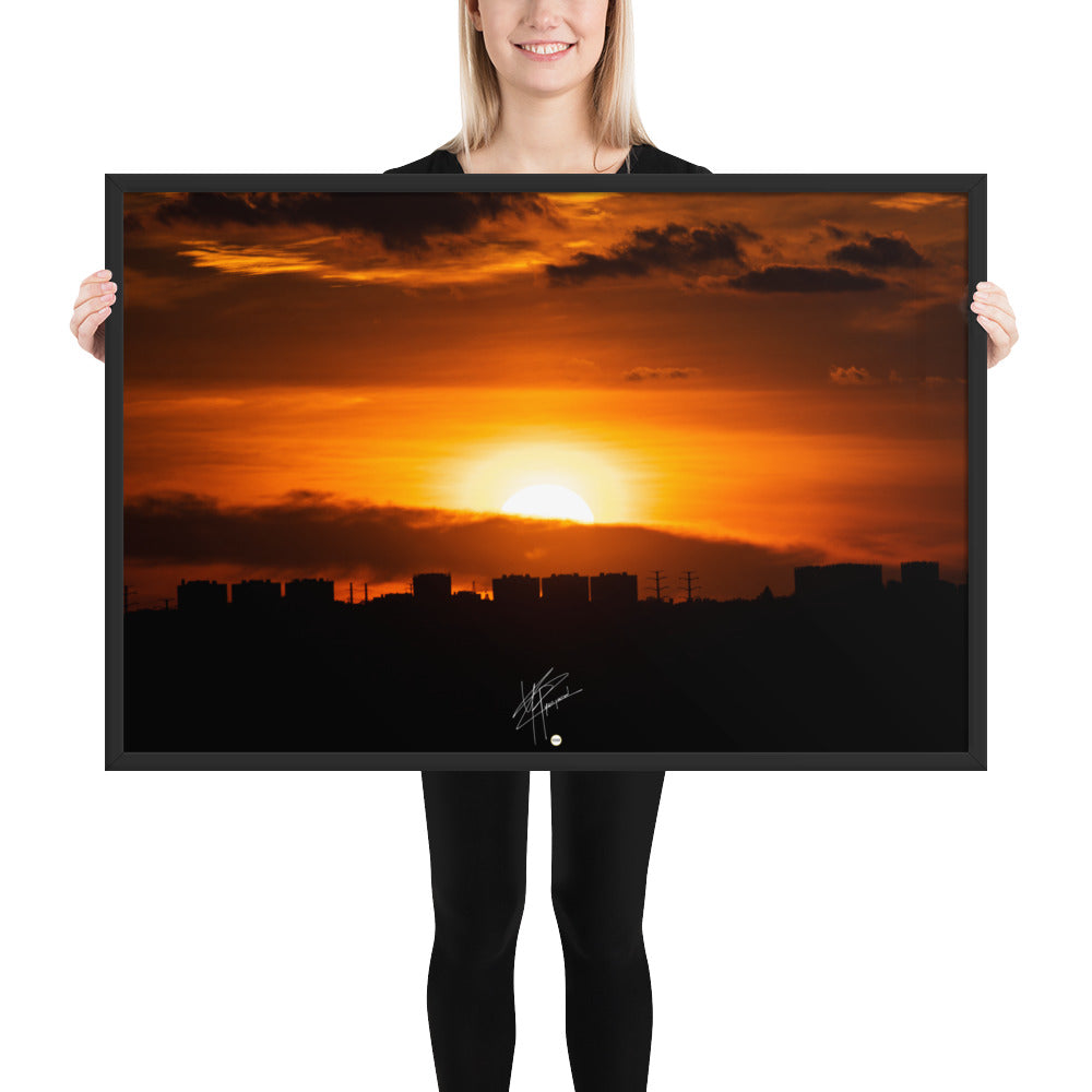 Vue panoramique d'une ville au coucher du soleil, où les bâtiments se découpent majestueusement contre le ciel orangé, évoquant calme et sérénité.