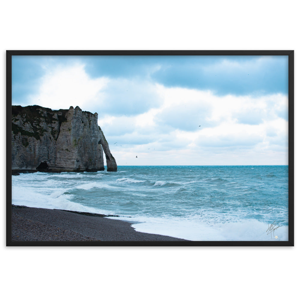 Photographie apaisante de la plage d'Etretat, où la mer caresse le rivage sous un ciel clair. Une représentation parfaite de la tranquillité et de la beauté naturelle de la côte normande.