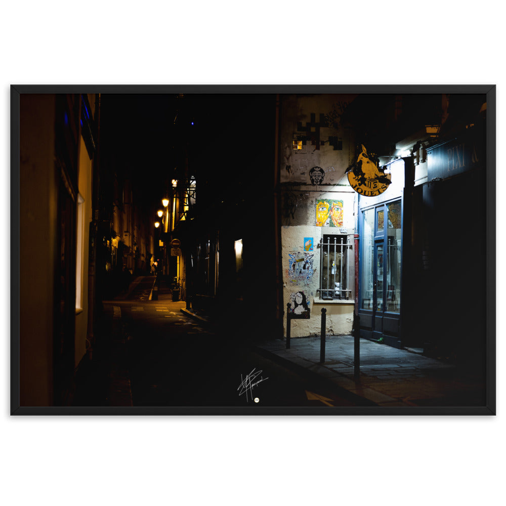 Photographie nocturne d'une rue parisienne, combinant éclats d'art urbain et lumière douce d'un magasin de jouets, évoquant la diversité et le charme artistique de la capitale.