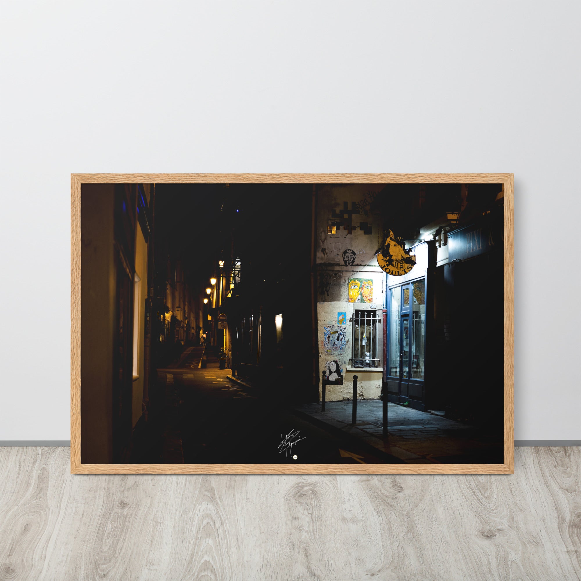 Photographie nocturne d'une rue parisienne, combinant éclats d'art urbain et lumière douce d'un magasin de jouets, évoquant la diversité et le charme artistique de la capitale.