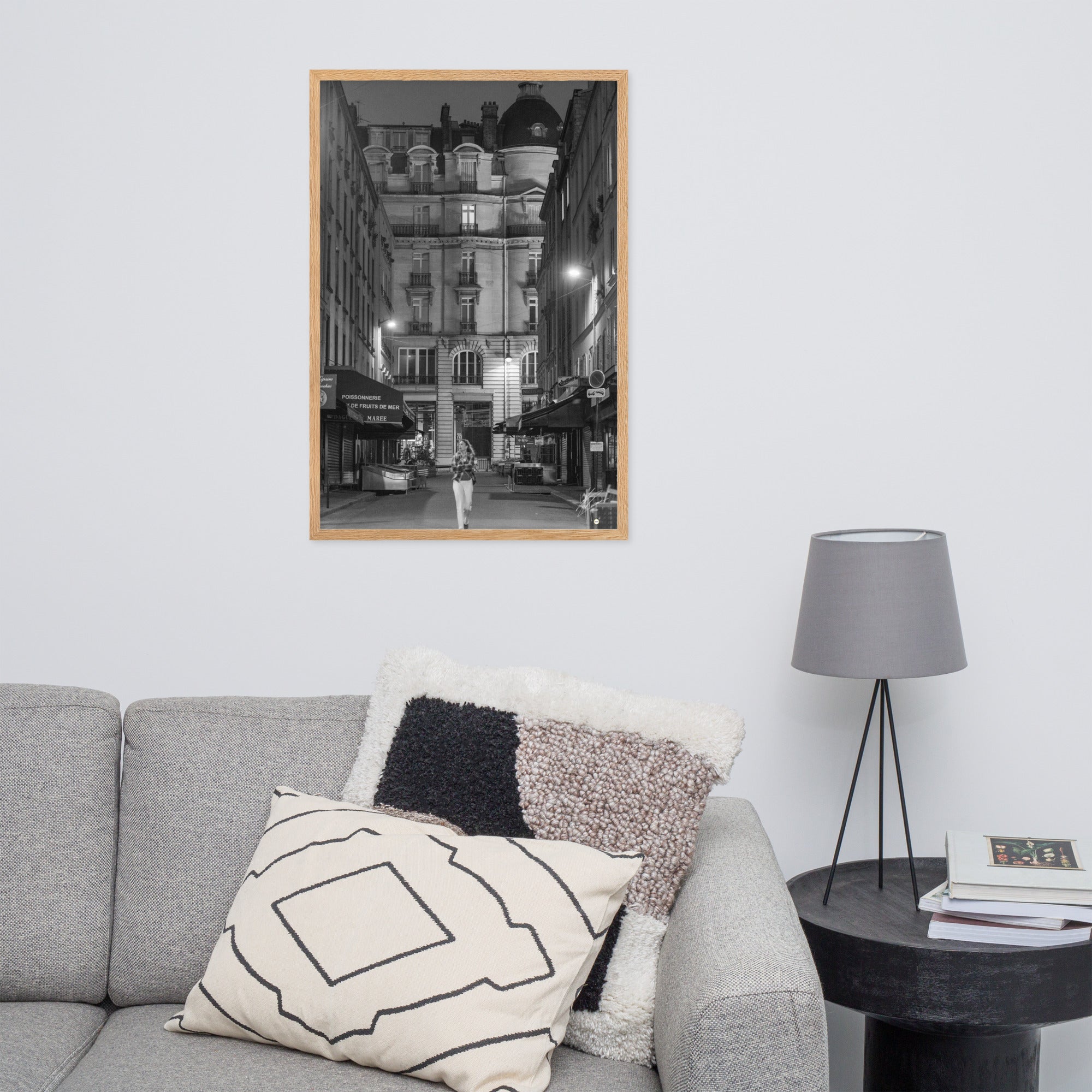Photographie en noir et blanc d'une rue parisienne déserte la nuit, illuminée par les lumières douces des lampadaires, évoquant une atmosphère mystérieuse et mélancolique.