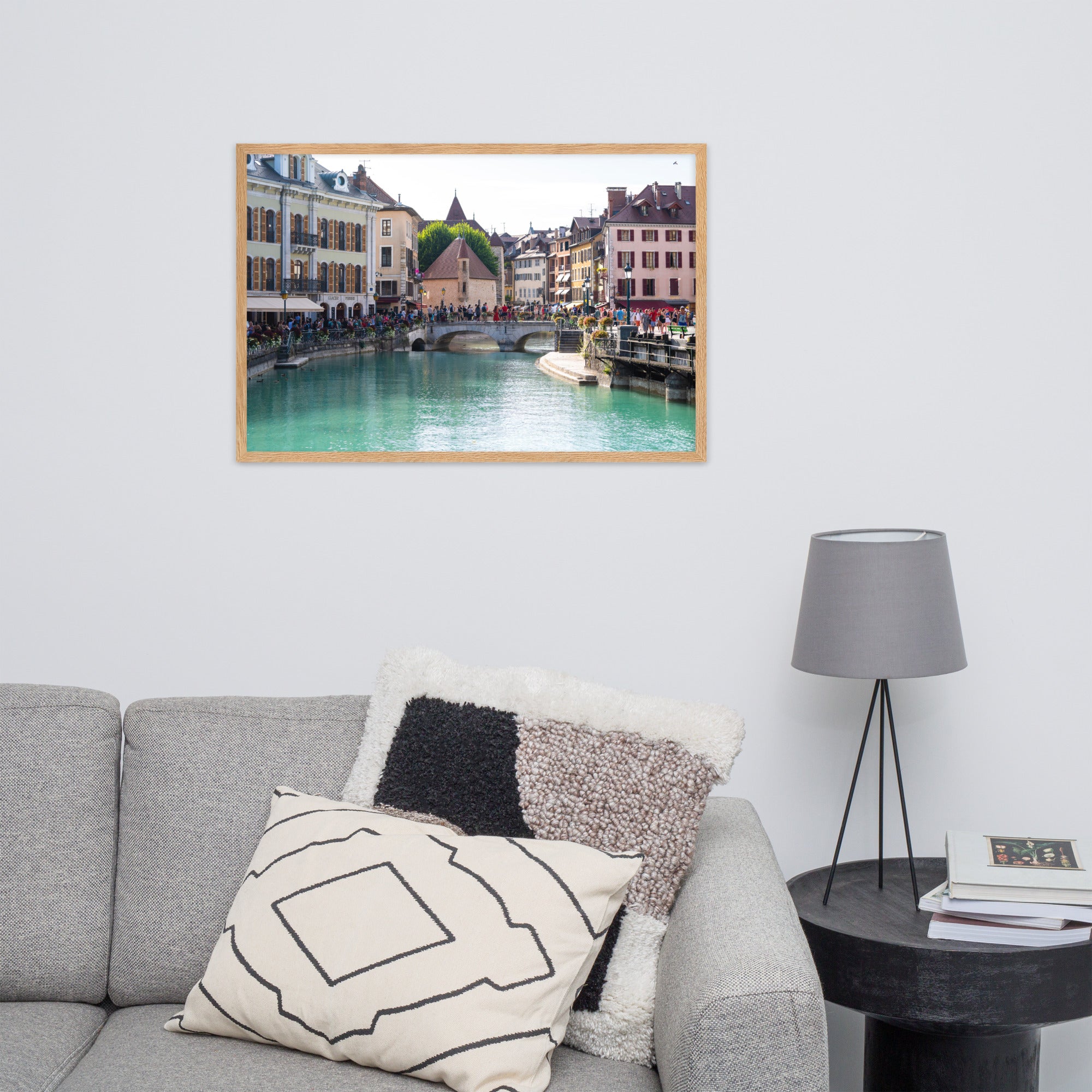 Vue estivale d'Annecy, mettant en lumière le Pont Perrière et le Palais de l'Île, encadrée d'un bois de chêne.