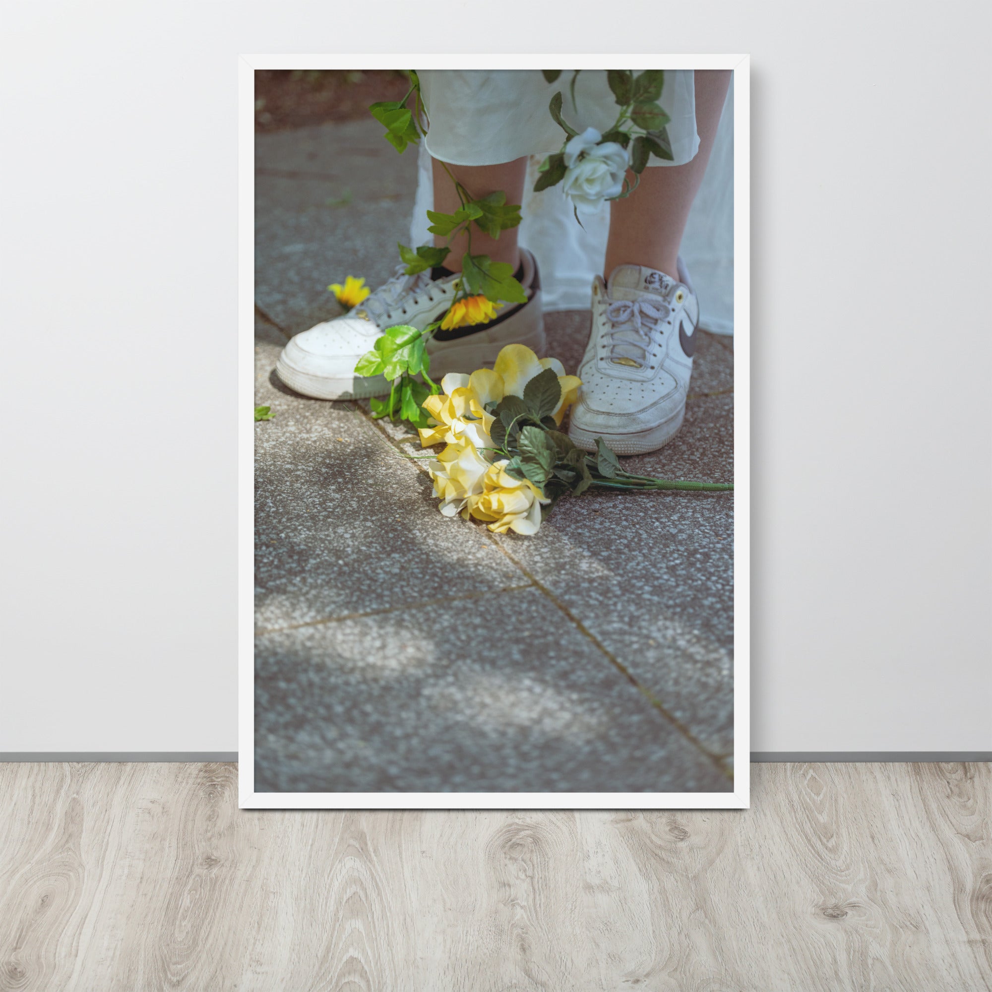 Poster encadré 'Flowers Nike' montrant des fleurs jaunes aux pieds d'une femme en blanc portant des Nike Air Force