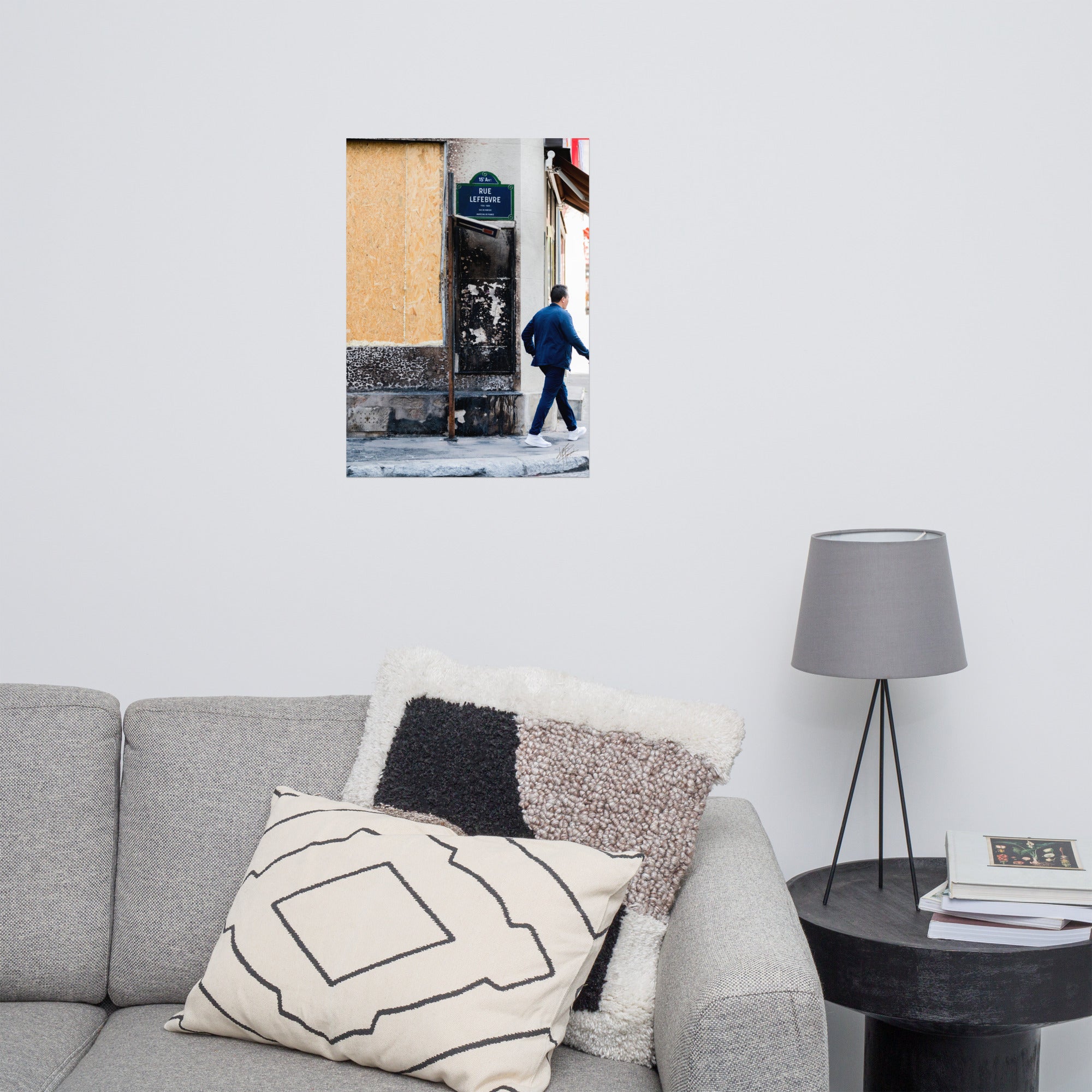 Photographie de la "Rue Lefebvre" après un incendie, montrant des traces de suie, un panneau de sens interdit plié et un passant.