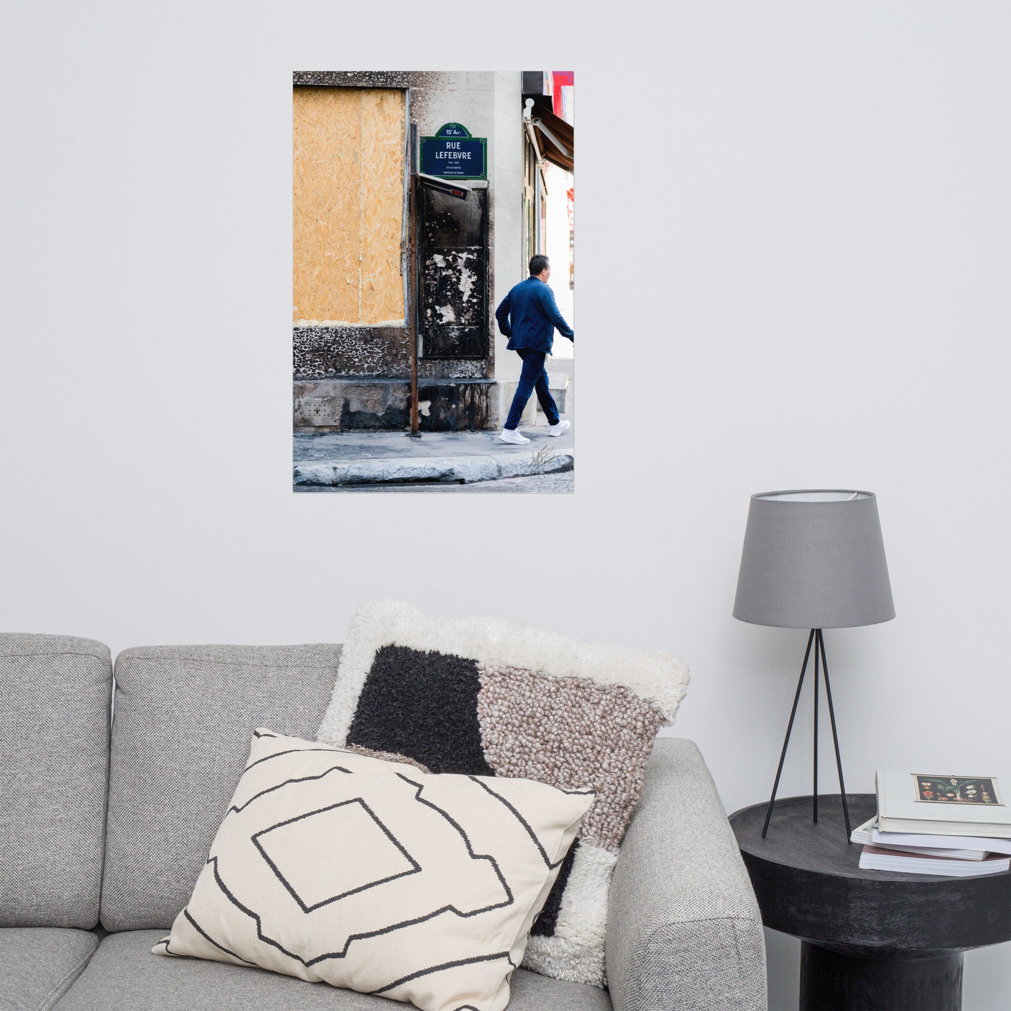 Photographie de la "Rue Lefebvre" après un incendie, montrant des traces de suie, un panneau de sens interdit plié et un passant.