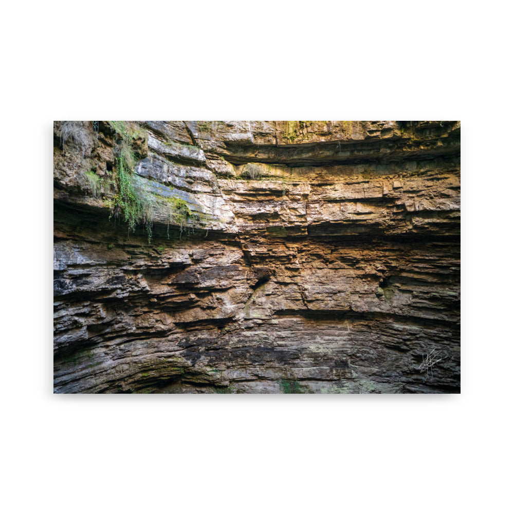 Photographie détaillée d'un mur de roche souterrain au gouffre de Padirac montrant des couches distinctes et des signes d'érosion.