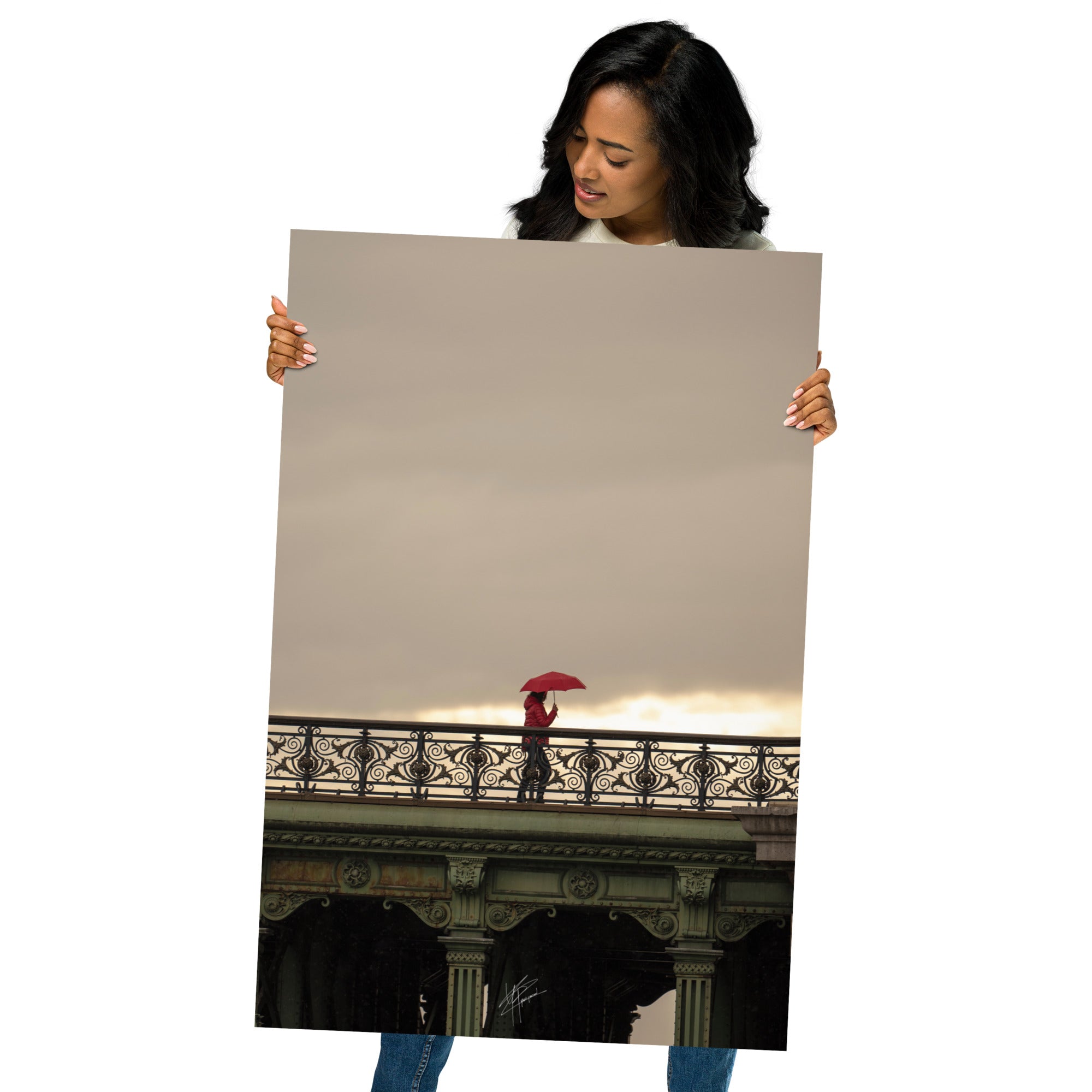 Photographie d'une femme traversant un pont parisien avec un parapluie rouge vif sur fond de paysage pluvieux.