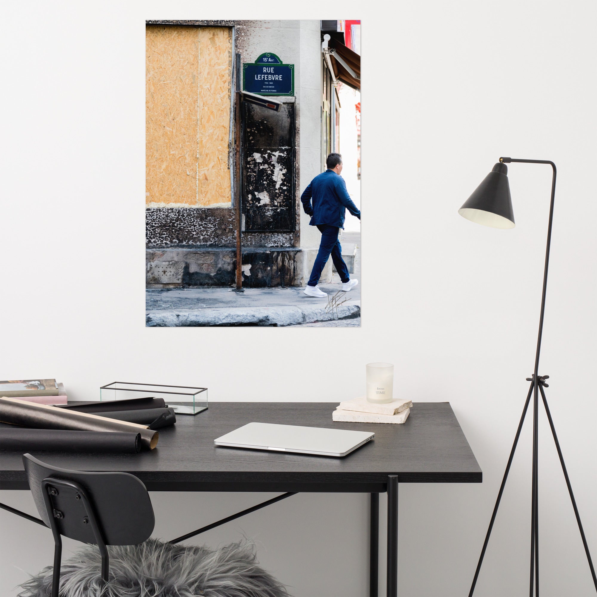Photographie de la "Rue Lefebvre" après un incendie, montrant des traces de suie, un panneau de sens interdit plié et un passant.