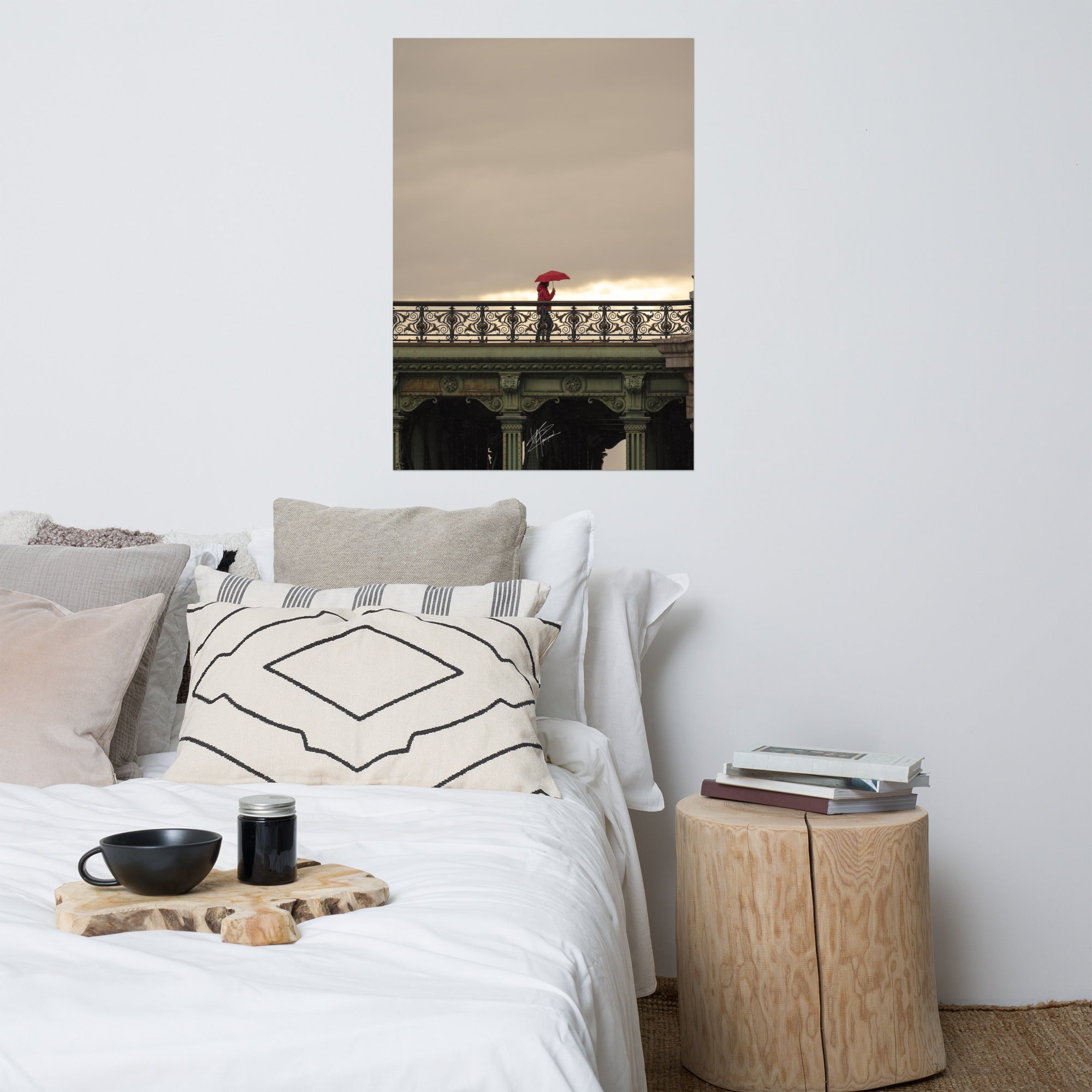 Photographie d'une femme traversant un pont parisien avec un parapluie rouge vif sur fond de paysage pluvieux.