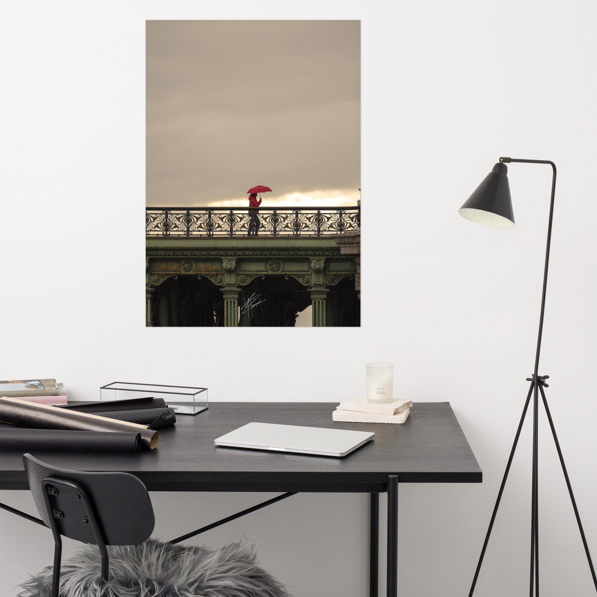 Photographie d'une femme traversant un pont parisien avec un parapluie rouge vif sur fond de paysage pluvieux.