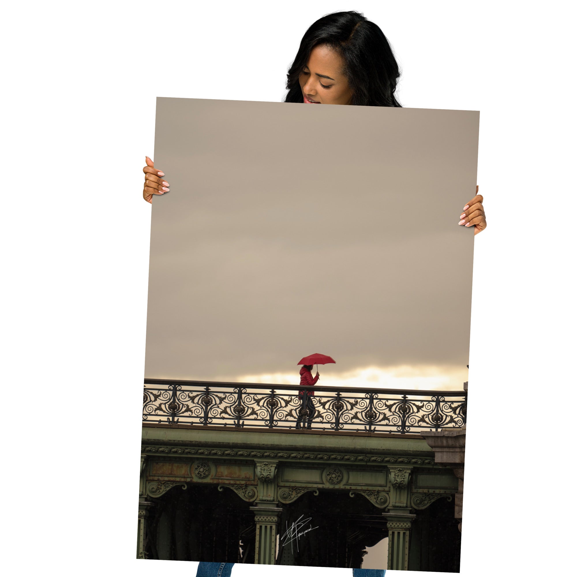 Photographie d'une femme traversant un pont parisien avec un parapluie rouge vif sur fond de paysage pluvieux.