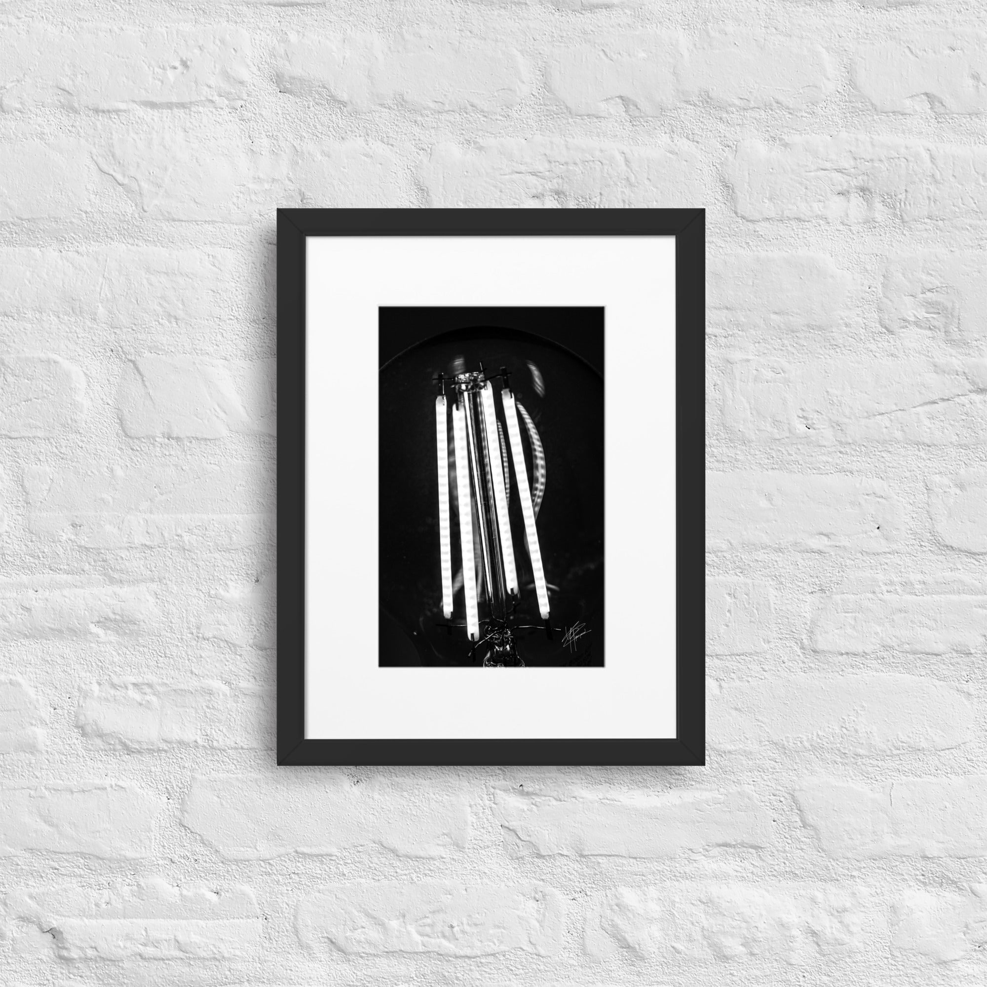 Photographie en gros plan d'une ampoule allumée en noir et blanc, où les filaments brillent de manière éclatante sur un fond sombre, encapsulant la beauté dans la simplicité.