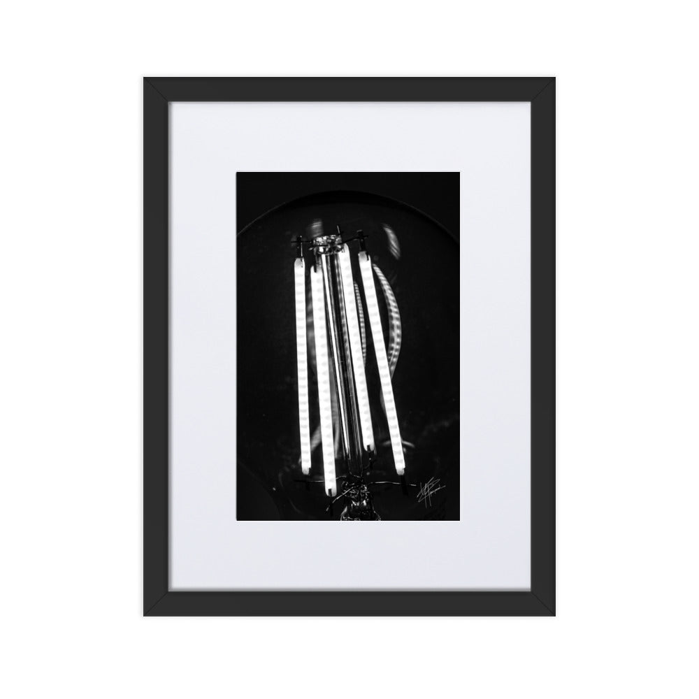 Photographie en gros plan d'une ampoule allumée en noir et blanc, où les filaments brillent de manière éclatante sur un fond sombre, encapsulant la beauté dans la simplicité.
