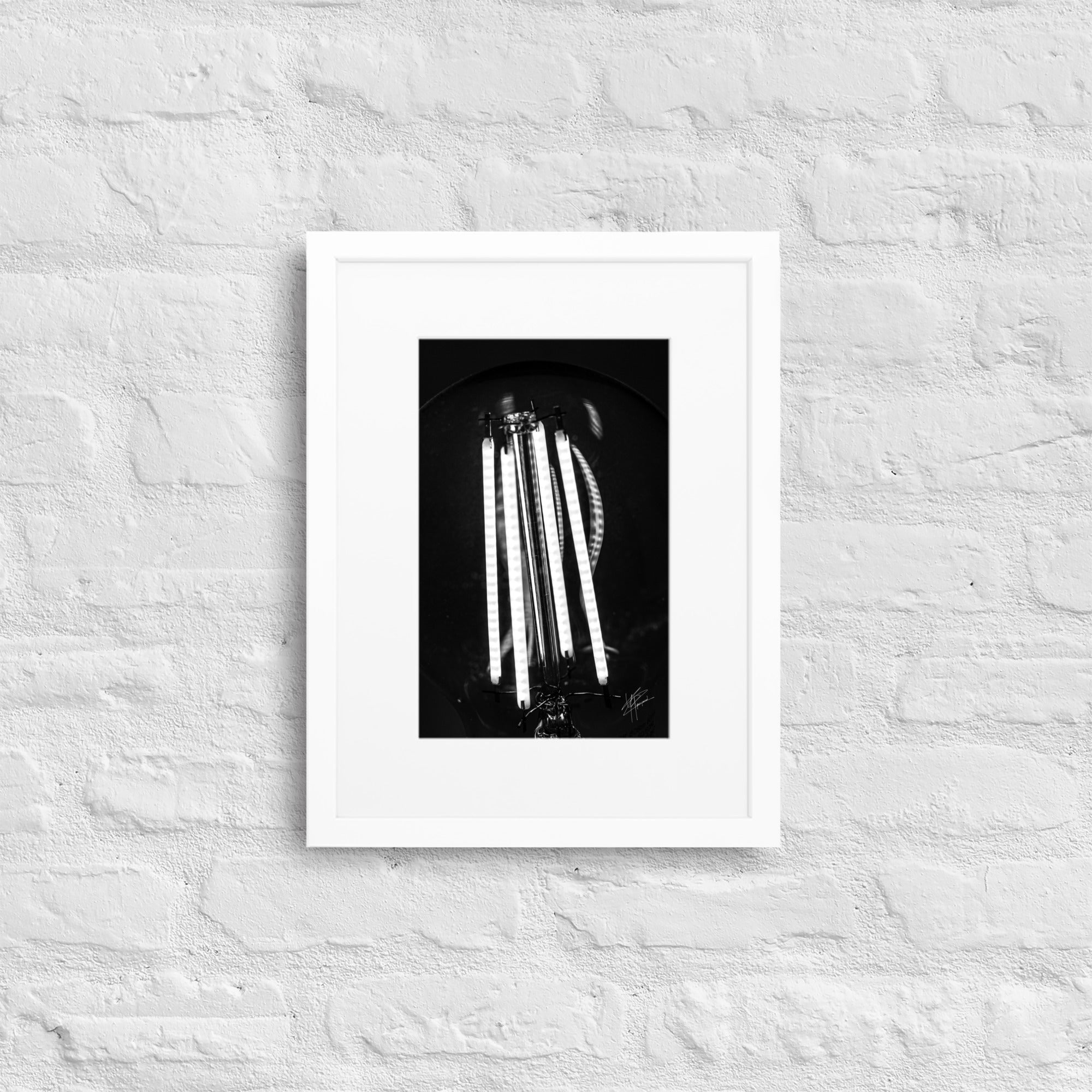 Photographie en gros plan d'une ampoule allumée en noir et blanc, où les filaments brillent de manière éclatante sur un fond sombre, encapsulant la beauté dans la simplicité.