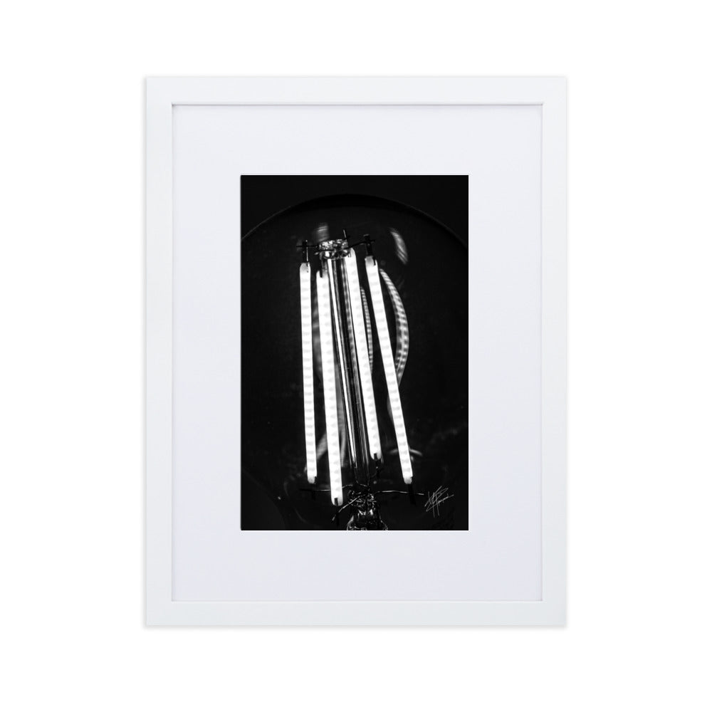 Photographie en gros plan d'une ampoule allumée en noir et blanc, où les filaments brillent de manière éclatante sur un fond sombre, encapsulant la beauté dans la simplicité.