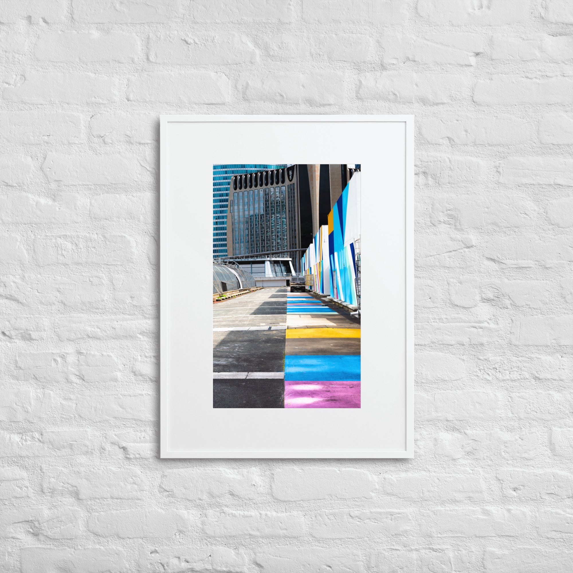 Poster encadré 'Palette' représentant une rue vibrante de couleurs contrastant avec des structures architecturales modernes, incarnant un mélange d'urbanisme et d'art.